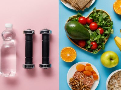 top view of diet food near dumbbells and water on blue and pink background